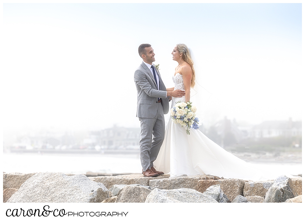 a groom walks toward his bride on the Kenneubnkport Breakwater