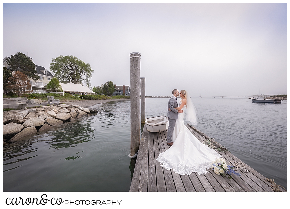 bride and groom on a dock as fog rolls in behind in Maine