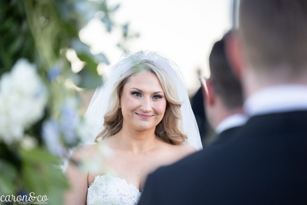 gorgeous bride looking into her partner's eyes during their wedding ceremony photographed by caron&co photography at the Cliff House Maine